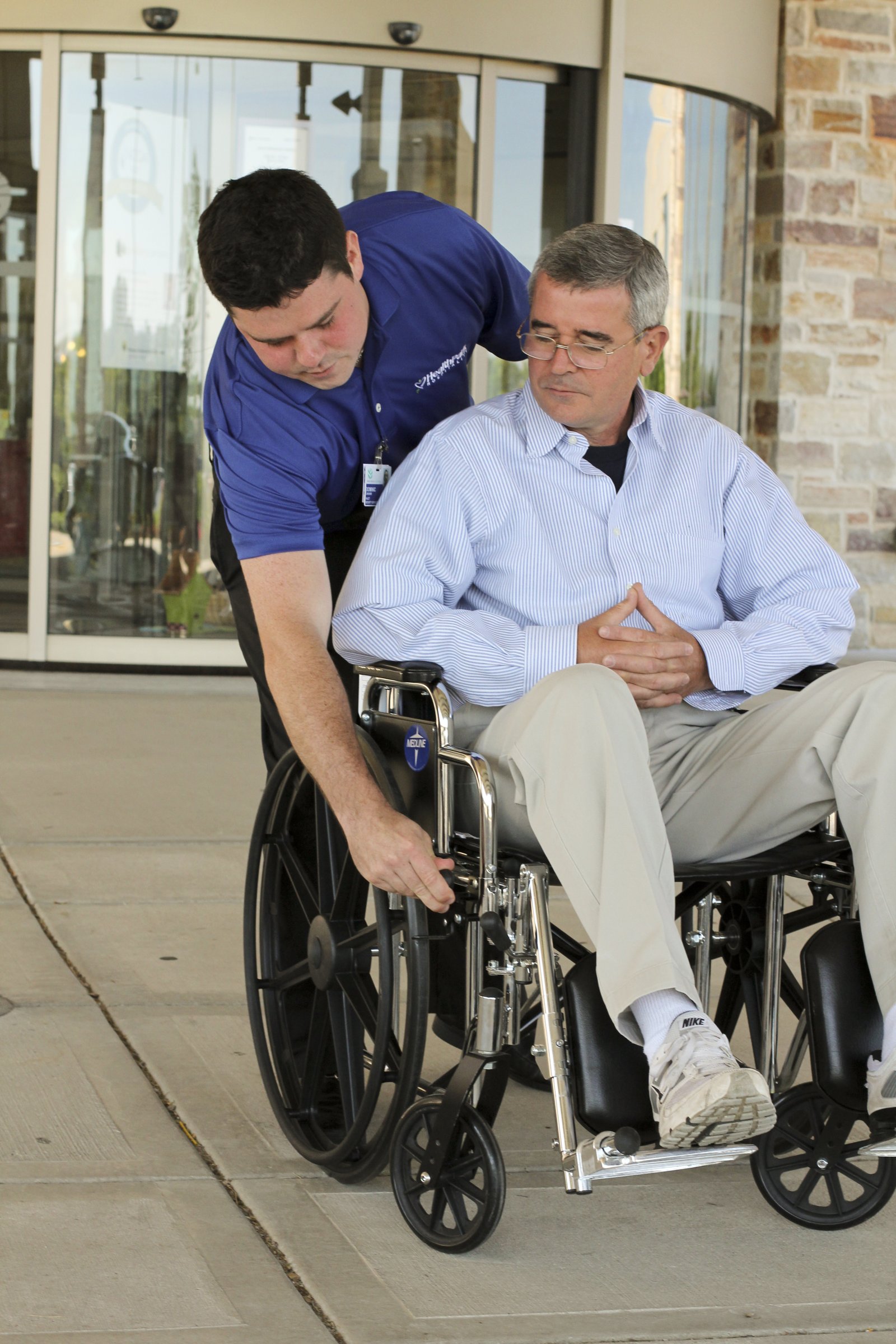 HealthPark associate assisting a patient using a wheelchair